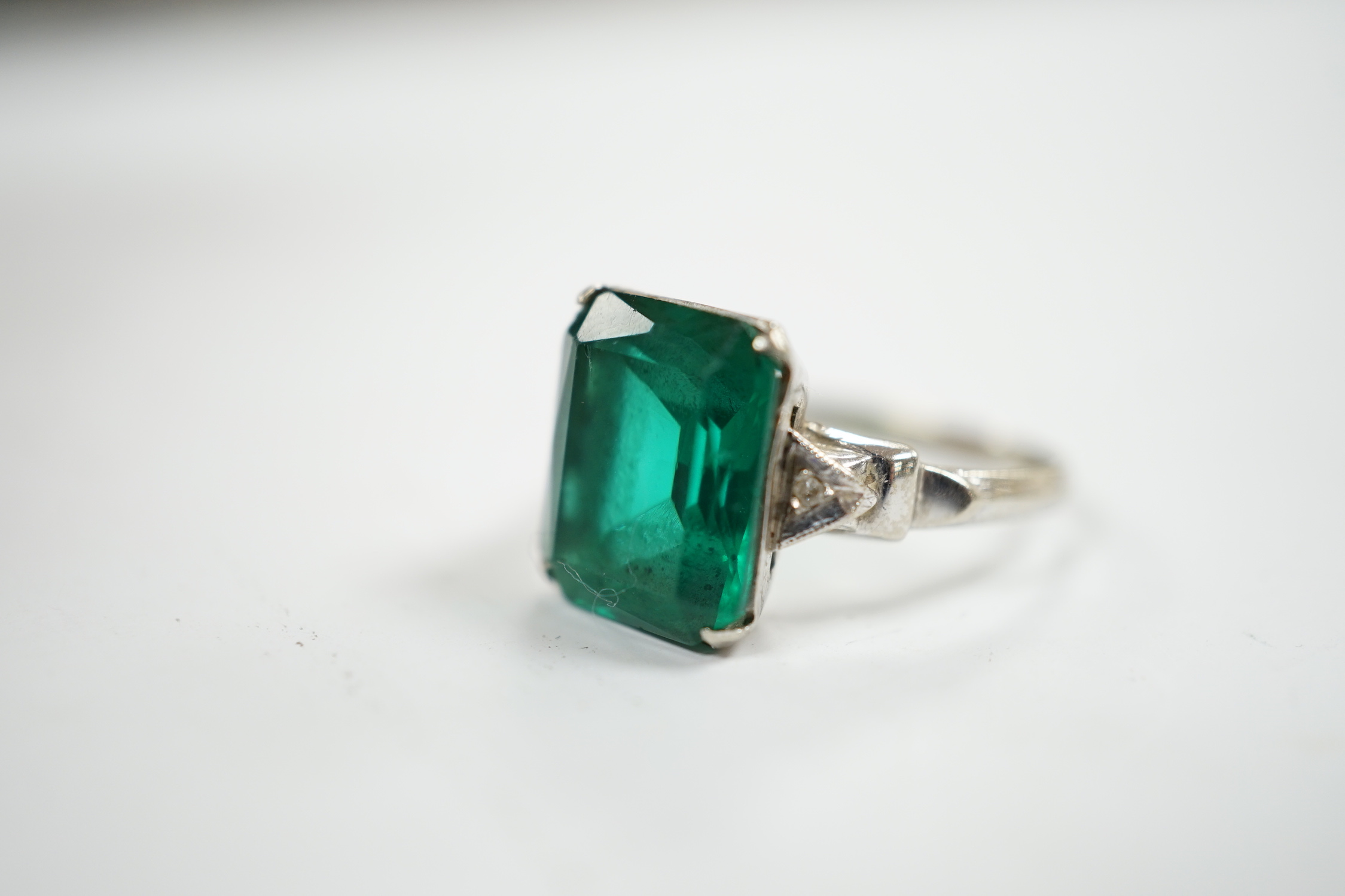 A 14k and single stone green paste set ring, with diamond chip set shoulders, size P, gross weight 3.5 grams.